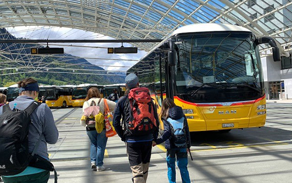 Escursionisti e autobus AutoPostale alla stazione di Coira